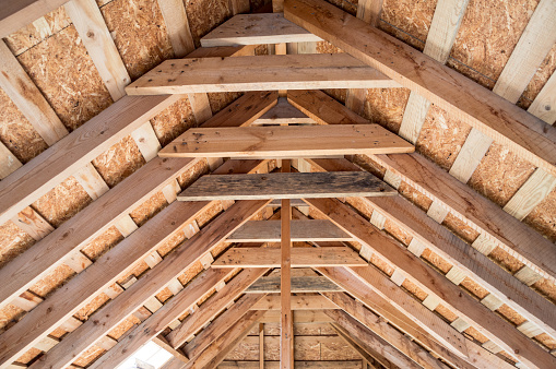 Attic of the house with wooden beams. Insulation of roofs and ceilings. Construction of houses.