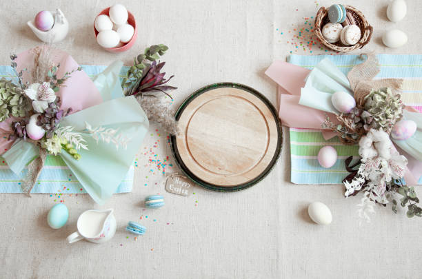 istock Easter dining table setting and decor with a wooden element in the center top view. 1291238475