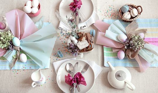 Decorated festive table with Easter dessert, tea and eggs flat lay. Happy Easter concept.