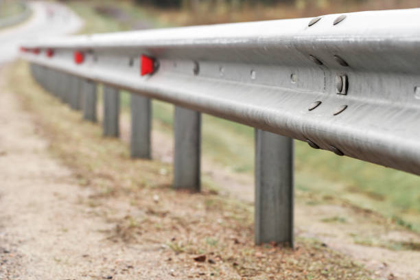 Metal guardrail with retro-reflecting optical units Metal guardrail with retro-reflecting optical units. Highway safety equipment, close-up photo with selective focus railings stock pictures, royalty-free photos & images