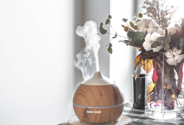 difusor moderno de aroma de aceite en la sala de estar en el espacio de copia de la mesa. - humidifier steam home interior appliance fotografías e imágenes de stock