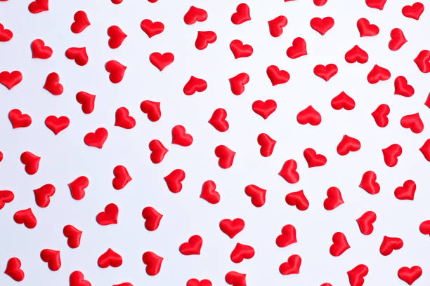 istock Valentine's day decorative pattern red hearts confetti on white background. 1291239763