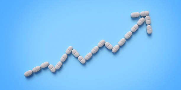 белые таблетки на синем фоне - vitamin pill capsule equipment data стоковые фото и изображения