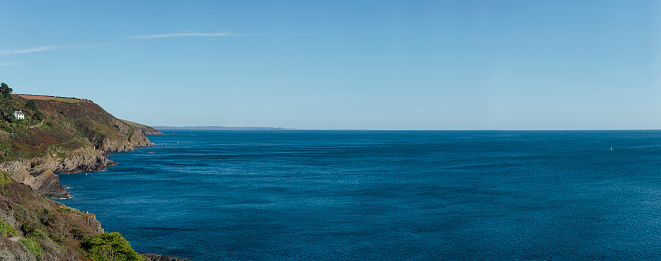 A wide shot of the Atlantic Ocean, at the side is the coastline of Polperro, Cornwall.