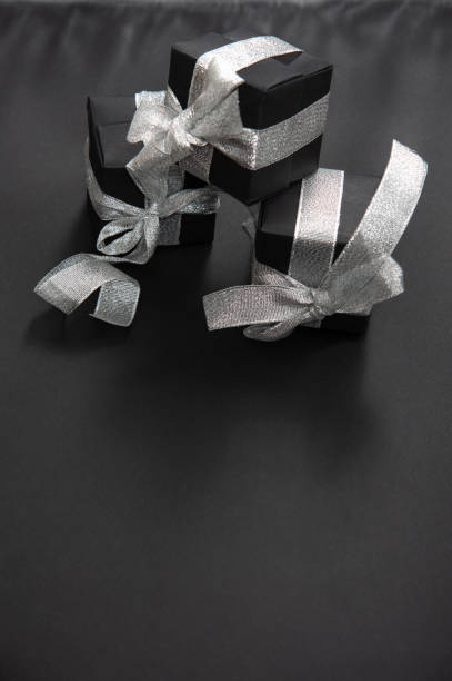 istock A pyramid of three black gift boxes tied with a silver ribbon. 1291247951