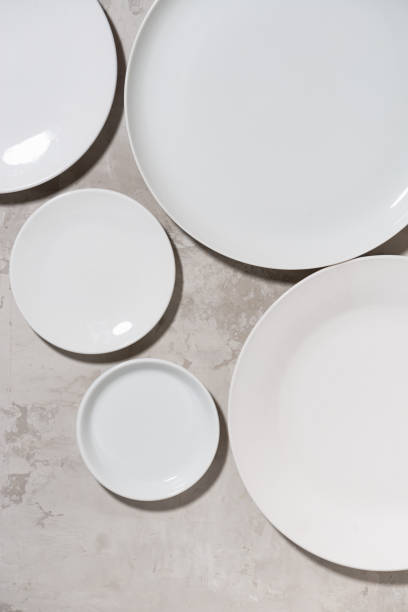 istock set of clean white plates on white background, vertical top view 1291252059