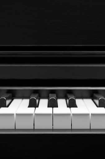 closeup of an Asian mature woman playing the keyboard piano, side view