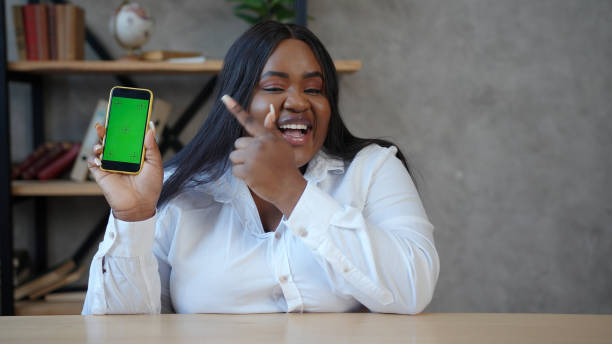 istock Lady shows with index finger to smartphone with chromakey 1291254652