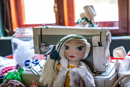 Homemade rag doll in front of sewing machine