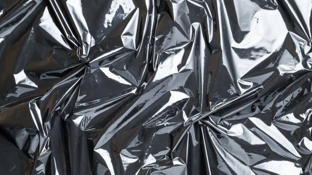 istock Smooth texture. Black shiny film bag pattern. Wrap transparent dark cellophane background. Real texture of polyethylene foil. 1291256072