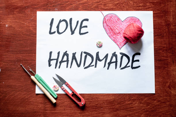 Table top view with sewing equipment and inscription love handmade