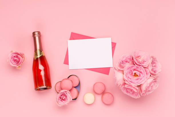 istock Flowers roses, envelope and sweets macaroons on pink background. Valentines day concept. Flat lay, top view, copy space. 1291257230