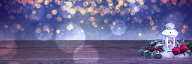 짙은 파란색의 흐릿한 조명 배경 앞에 있는 나무 테이블에 있는 흰색 크리스마스 등불. - christmas wood ambient candlestick holder 뉴스 사진 이미지