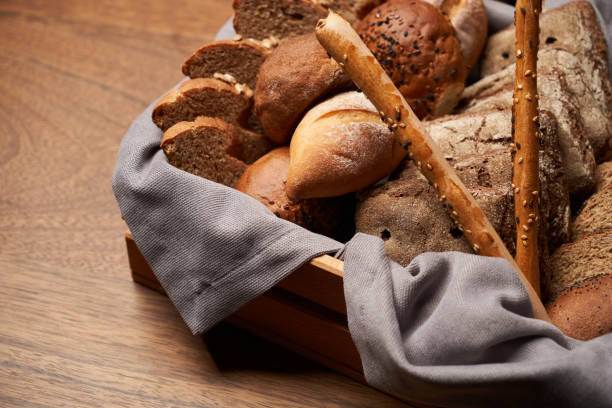 istock Basket with fresh bread on wooden table background 1291258109
