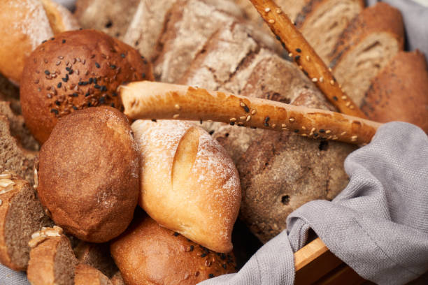 istock Basket with fresh bread on wooden table background 1291258111