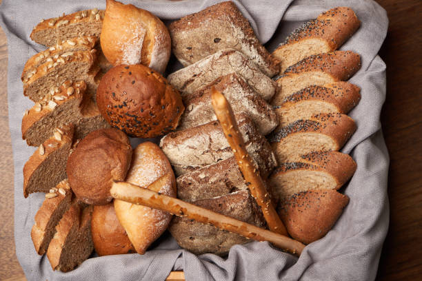 istock Basket with fresh bread on wooden table background 1291258115