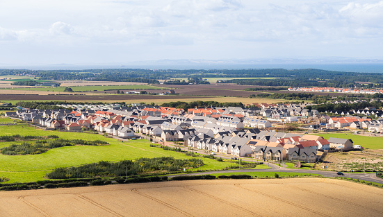 A high angle view over a large housing development of detached and semi-detached homes near the East Lothian town of North Berwick, Scotland.