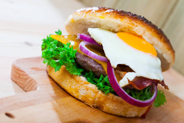 istock Hamburger with beef patty, cheese, fried egg and lettuce 1291260952