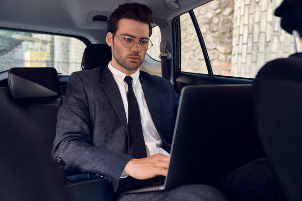 istock Great solutions every day. Confident young businessman working on his laptop while sitting in the car 1291261981