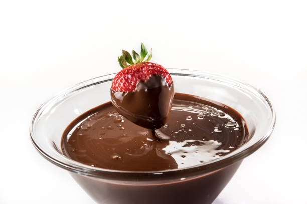 istock Chocolate dripping from strawberry into glass cup 1291264511