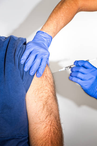 Adult caucasion man receives Covid-19 vaccination from a doctor Adult caucasion man receives Covid-19 vaccination from a doctor crista ampullaris photos stock pictures, royalty-free photos & images