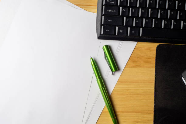 istock Notebook and laptop on old wooden desk 1291267335