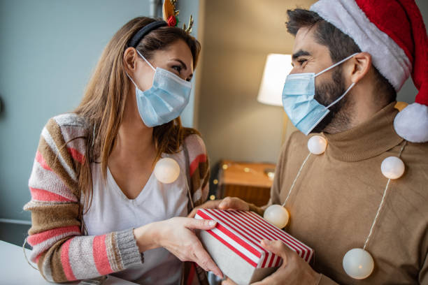 istock Couple at home with protective face mask celebrating Christmas 1291268616
