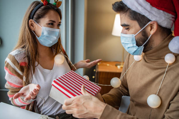 istock Couple at home with protective face mask celebrating Christmas 1291268812