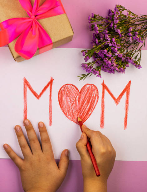 istock hands make a red pencil card for mom with mother's day, top view 1291269184