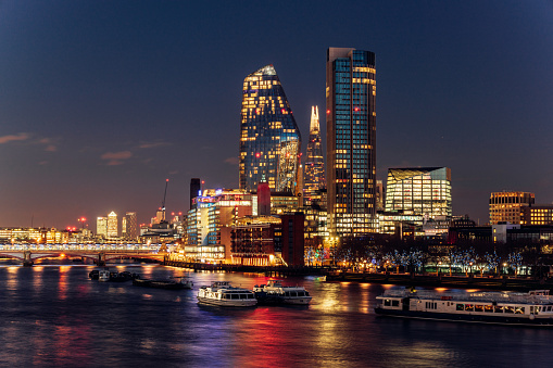 London skyline at night over Thames river. Illuminated skyscrapers.