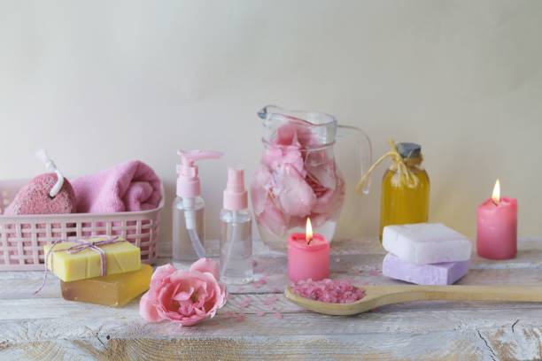 istock Fresh pink roses, water, petals, candles on a light background 1291269307