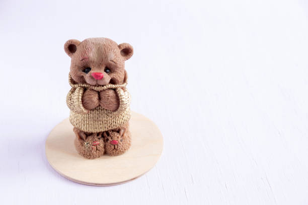 istock Chocolate bear figurine on a wooden backing. White background with space for text. Selective focus. 1291270207