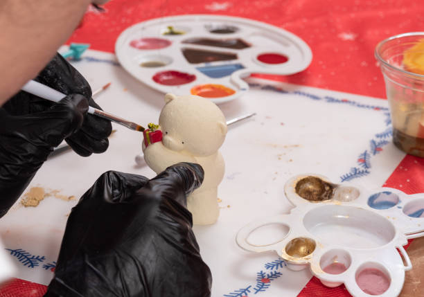 istock Paint a part of a chocolate polar bear figurine with a brush. Selective focus. 1291270302