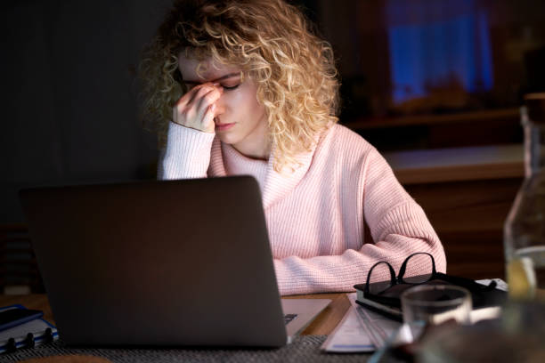 istock Exhausted woman working on a laptop at home 1291270401