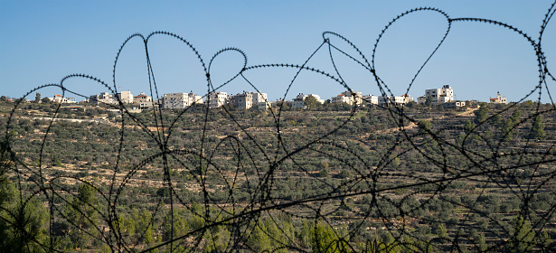 Beit Surik, Israel - December 3rd, 2020: The palestinian village Beit Surik, behind barbed wire, as seen from the israeli side of the fence.