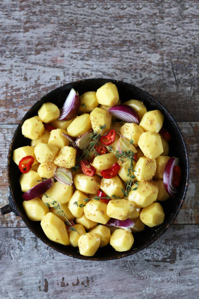 istock Raw potatoes in a pan with spices before baking. 1291272098