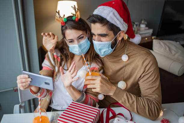 istock Couple at home with protective face mask celebrating Christmas 1291272142