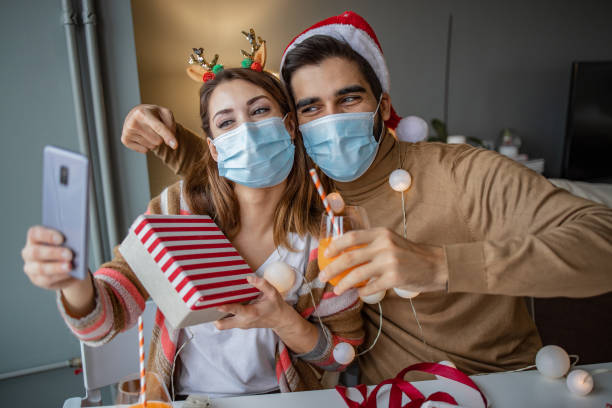 istock Couple at home with protective face mask celebrating Christmas 1291272182