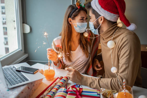 istock Couple at home with protective face mask celebrating Christmas 1291272248