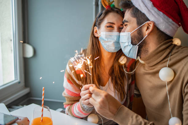 istock Couple at home with protective face mask celebrating Christmas 1291272251
