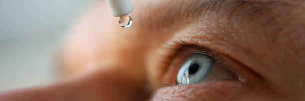 man drops eye drops install lenses, moisturizing - wide screen imagens e fotografias de stock