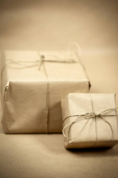 istock two gift package wrapped with plain brown paper and rope and brown paper background texture, retro gift box. present concept 1291274615