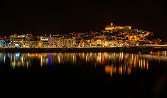 Panoramic view of Coimbra at night from the left bank of the Mondego River.