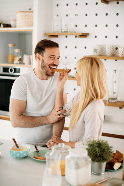 istock Young couple having fun while eating a breakfast. stock photo 1291276345