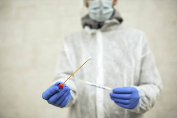 istock Doctor showing covid-19 tube test and sampling swab 1291279081