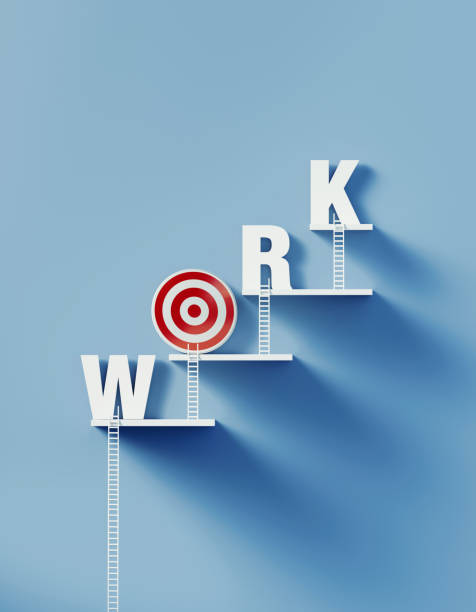 istock White Ladders Leans over A Bull's Eye Target and Writes Work on Blue Wall 1291279349