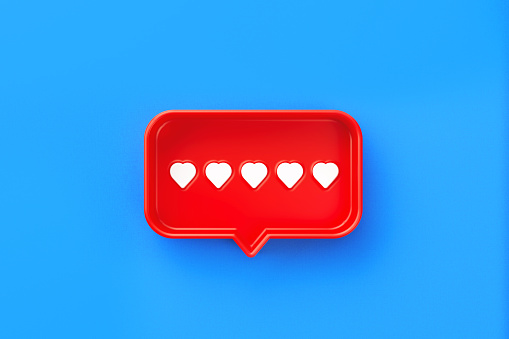 Red chat bubble with heart symbols inside on blue background. Horizontal composition with copy space. Rating and survey concept.
