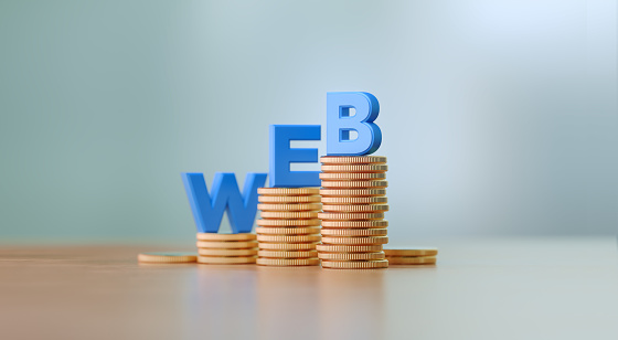 Blue capital letters sitting on coins stacks writes web before defocused background. Horizontal composition with copy space. Great use for e-commerce concepts.