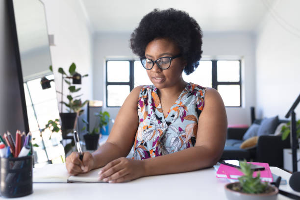 istock African american female vlogger recording a video writing in notebook 1291282477