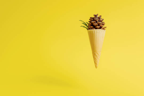 istock Pine cone in ice cream cone on yellow background 1291283322